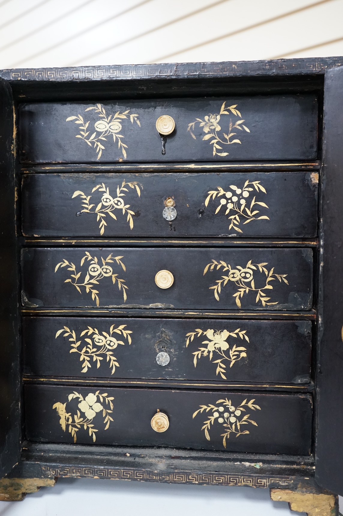 A mid 19th century Chinese export gilt-decorated lacquer two door cabinet, with five drawers, 38cm
